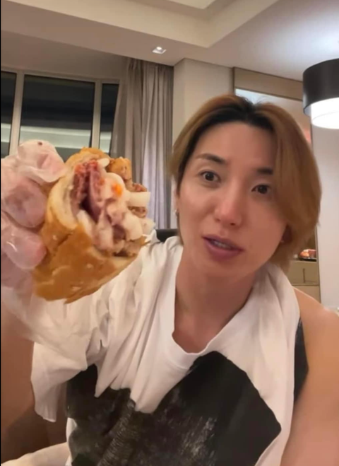 4 món Việt 'chui tọt' bao tử Leeteuk (Super Junior) khi ở TP.HCM - Ảnh 1. Leeteuk ăn bánh mì sau đêm diễn 21-10.