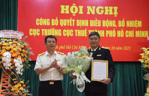 Cục Thuế TP.HCM có tân cục trưởng - Ảnh 1. Ông Mai Xuân Thành (bìa trái), tổng cục trưởng Tổng cục Thuế, trao quyết định cho ông Nguyễn Nam Bình - Ảnh: A.H.