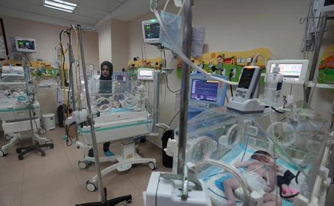 Hiện tượng mới ở Dải Gaza: Những dòng tên viết bằng mực đen trên bụng trẻ - Ảnh 2. Một bác sĩ Palestine điều trị cho một bé sinh non tại Bệnh viện Al Aqsa ở Deir el-Balah, Gaza, ngày 22-10 - Ảnh: CNN