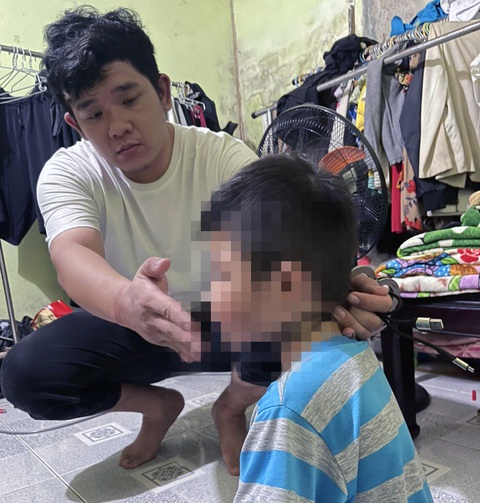 Khởi tố cha ruột đánh con trai 5 tuổi chi chít vết thương - Ảnh 1. Công an cho Dương Nguyễn Bình Minh thực nghiệm để điều tra hành vi bạo hành con - Ảnh: A.B.