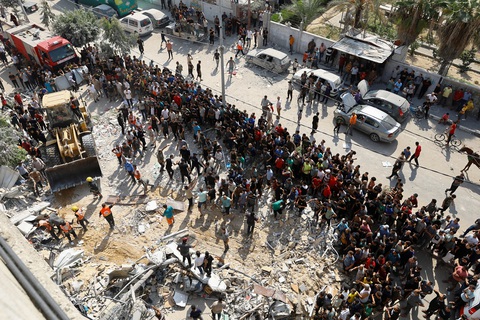 Toàn cảnh lập trường của tổng thư ký Liên Hiệp Quốc trong vụ Israel - Hamas - Ảnh 2. Người Palestine tập trung tại hiện trường một ngôi nhà bị Israel tấn công ở thành phố Khan Younis, phía nam Dải Gaza ngày 24-10 - Ảnh: REUTERS