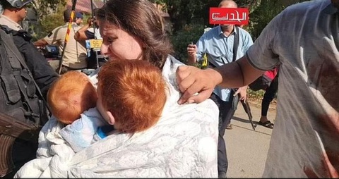 Những con tin bé bỏng bên lề cuộc chiến Israel-Hamas - Ảnh 2. Cô Shiri ôm hai đứa con trai tóc đỏ, Ariel, 4 tuổi và bé Kfir 10 tháng tuổi bị bắt lên xe - Ảnh: DAILY MAIL