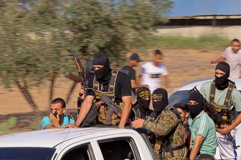 Hamas qua mặt tình báo Mỹ, Israel bằng điện thoại có dây suốt 2 năm - Ảnh 1. Nhóm chiến binh Hamas tiến đến hàng rào biên giới Israel từ vùng Khan Younis ở phía nam Dải Gaza hôm 7-10 - Ảnh: AFP/GETTY IMAGES