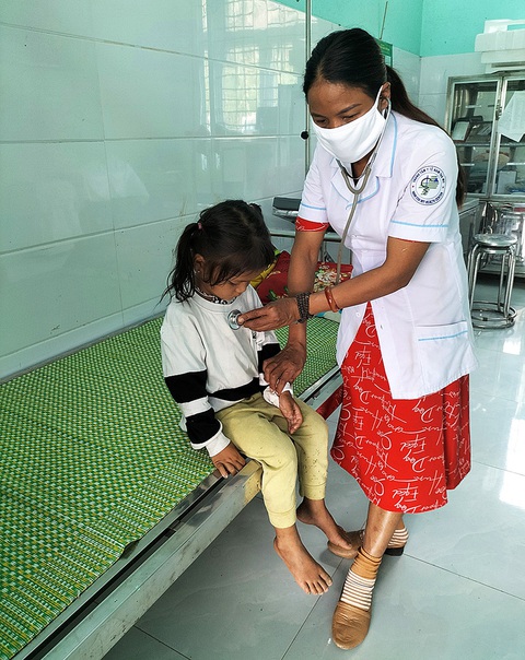 Gặp lại người cứu bé trai suýt bị chôn sống theo mẹ - Ảnh 3. Nữ trưởng trạm Hồ Thị Hiếu khám bệnh cho trẻ em bản làng và được người dân thương quý - Ảnh: M.T.
