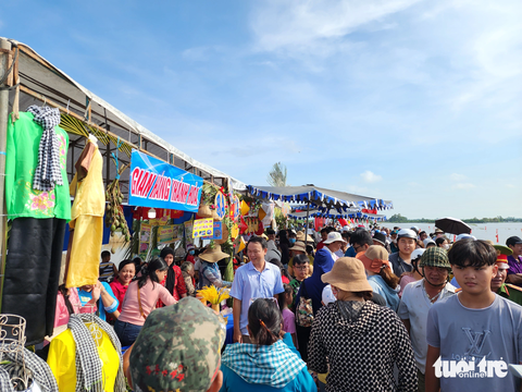 Hàng ngàn người ‘đội nắng’ xem đua xuồng trên cánh đồng lũ - Ảnh 4. Hàng ngàn người đổ xô chật kín trên tuyến đường 945, đoạn xã Thạnh Mỹ Tây, huyện Châu Phú kéo dài gần 2km - Ảnh: BỬU ĐẤU