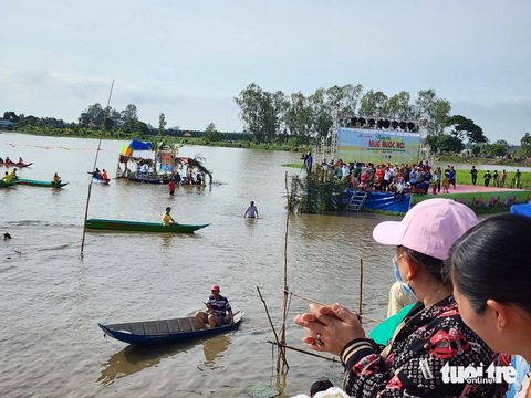 Hàng ngàn người ‘đội nắng’ xem đua xuồng trên cánh đồng lũ - Ảnh 7. Người dân đứng chật kín khắp tuyến đường để cổ vũ các đội đua xuồng tranh tài - Ảnh: BỬU ĐẤU