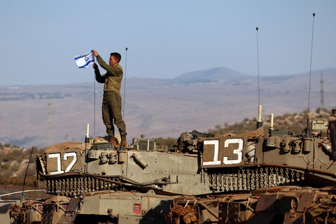 Israel xác nhận đã vào Gaza, diệt chỉ huy cốt cán của Hamas - Ảnh 1. Binh sĩ Israel treo cờ lên xe tăng trong một hoạt động quân sự - Ảnh: REUTERS