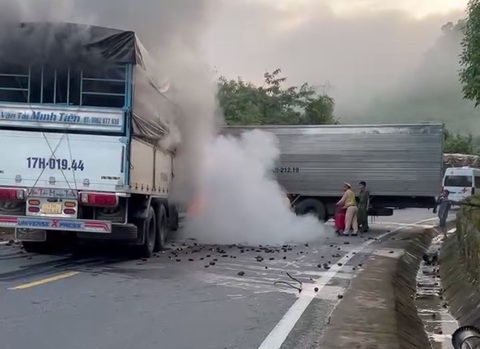 Sau va chạm trên đường Hồ Chí Minh, xe tải bốc cháy ngùn ngụt - Ảnh 3. Lực lượng công an dùng bình cứu hỏa dập lửa - Ảnh: M.T.