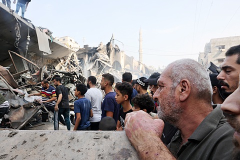 Lửa cuồng nộ của Israel ở Gaza - Ảnh 1. Người dân ở TP Gaza nhìn các tòa nhà bị đánh sập sau đợt không kích của Israel ngày 28-10 - Ảnh: AFP