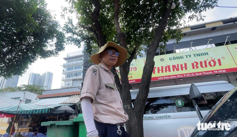 Xe Thành Bưởi tạm ngưng chở khách từ hôm nay - Ảnh 3. Một nhân viên xe Thành Bưởi đang hướng dẫn khách gửi hàng - Ảnh: LÊ PHAN