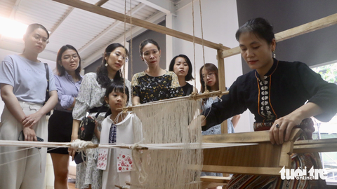 'Se gai sẻ gánh' với chị em H'mông thôn nghèo Sán Séo Tỷ - Ảnh 4. Nghệ nhân Sầm Thị Tình (37 tuổi, Nghệ An) hướng dẫn người tham dự dệt vải từ sợi gai dầu - Ảnh: THÁI THÁI