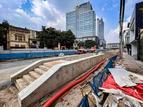 Ga ngầm S12 metro Nhổn - ga Hà Nội lỡ hẹn, chưa hoàn trả mặt đường - Ảnh 1. Đến nay, việc xây lắp ga ngầm S12 đoạn qua khu vực đầu đường Trần Hưng Đạo đã xong các kết cấu cơ bản. Phần cửa đi xuống hầm nổi lên khỏi mặt đất đang được hoàn thiện các phần việc còn lại - Ảnh: HỒNG QUANG