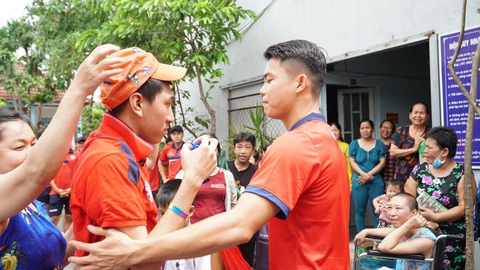 Thủ môn Filip Nguyễn, Văn Thanh đá gây quỹ từ thiện trên sân Thống Nhất - Ảnh 2. Đội trưởng CLB TP.HCM Ngô Tùng Quốc (phải) động viên một bệnh nhân tại nhà trọ 0 đồng - Ảnh: HCMFC