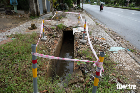 10 năm liền 'đá nhau' duy tu 13km vỉa hè, dải cây xanh quốc lộ 1A - Ảnh 4. Một đoạn cống vỉa hè hư hỏng nhưng chưa được sửa chữa - Ảnh: HOÀNG TÁO