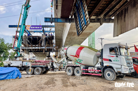 Hợp long nhịp chính của cây cầu Nam Lý, sớm đưa công trình 'về đích' - Ảnh 2. Đơn vị xây dựng đang tải bê tông, nối nhịp cầu Nam Lý vào chiều 30-10 - Ảnh: CHÂU TUẤN