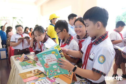 Bàn giao sách cho cơ sở trên địa bàn TP.HCM - Ảnh 6. Học sinh Trường tiểu học Nguyễn Bình (huyện Nhà Bè, TP.HCM) thích thú đọc sách tại lễ bàn giao sách diễn ra trong sáng 31-10 - Ảnh: NGỌC PHƯỢNG