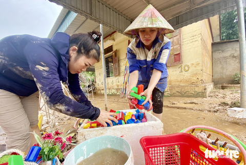 Thủy điện xả lũ trong đêm, huyện không nhận được thư thông báo? - Ảnh 1. Các cô giáo Trường mầm non Châu Hạnh, huyện Quỳ Châu, Nghệ An rửa lại đồ chơi của học trò sau mưa lũ - Ảnh: DOÃN HÒA