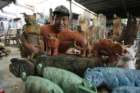 UNESCO gọi tên Hội An trong danh sách các thành phố sáng tạo toàn cầu - Ảnh 3. Nghệ nhân Lê Ngọc Thuận, chủ xưởng mộc nghệ thuật Làng Củi Lũ, với bộ sưu tập mèo gỗ làm từ gỗ mục - Ảnh: B.D.