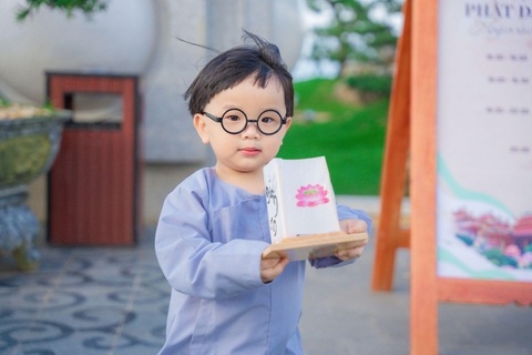 Lên núi Bà Đen dâng đăng dịp Lễ Vía Quán Thế Âm xuất gia - Ảnh 3. Em bé hoan hỉ dâng đăng trên núi Bà Đen - Ảnh: Hải Triều