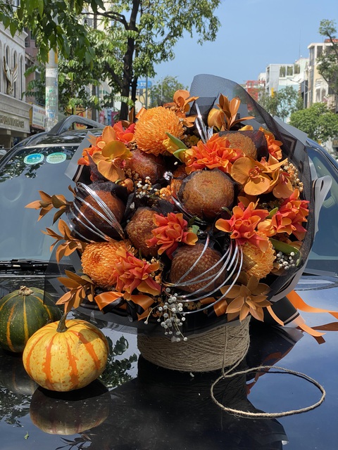 Ngắm những mẫu hoa trang trí ma mị mùa Halloween - Ảnh 1. Một mẫu hoa được thiết kế riêng cho mùa Halloween. Để tạo điểm nhấn "ma mị", hoa được sơn thêm sắc cam và phủ một lớp voan đen kỳ bí, giá bó hoa đang được niêm yết 1,7 triệu đồng/bó - Ảnh: Dalat Hasfarm