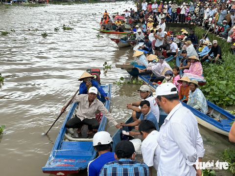 Hơn 700 vận động viên tranh tài đua ghe ngo sôi nổi - Ảnh 2. Đông đảo người dân đứng kín cả đoạn sông cổ vũ các đội đua ghe ngo tại huyện Giồng Riêng năm 2023 - Ảnh: HOA ÁNH