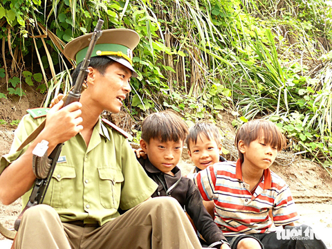 Chuyện chưa kể sau những tấm ảnh đặc biệt - Kỳ 3: Người lính nơi sông Hồng chảy vào nước Việt - Ảnh 3. Bọn trẻ thân thiện khoác vai chuyện trò với anh lính biên phòng - Ảnh: QUỐC VIỆT