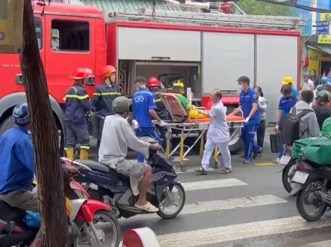 Cảnh sát giải cứu cô gái bị kẹt tay vào máy ép nước mía - Ảnh 1. Nạn nhân được chuyển lên xe cứu thương đưa vào bệnh viện - Ảnh do người dân cung cấp