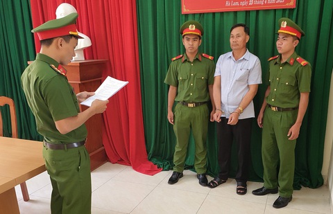Bắt người đàn ông khai thác trái phép 56 cây gỗ rừng phòng hộ - Ảnh 1. Cơ quan cảnh sát điều tra đọc quyết định khởi tố, lệnh bắt tạm giam ông Long - Ảnh: TRANG PHƯƠNG