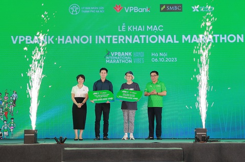 11.000 VĐV dự giải chạy VPBank Hanoi International Marathon 2023 - Ảnh 3. Ông Đỗ Đình Hồng - giám đốc Sở Văn hóa và Thể thao Hà Nội (bìa phải) - và bà Phạm Thị Nhung (bìa trái) trao 300 triệu đồng cho chương trình 'Cặp lá yêu thương' và Tổ chức Newborns - Ảnh: VPBank