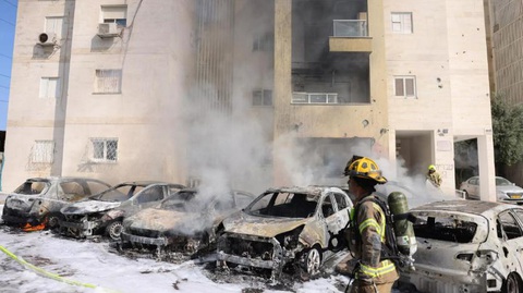 Cuộc tấn công của Hamas nhắm vào Israel: Chảo lửa âm ỉ hơn 70 năm - Ảnh 1. Đội cứu hỏa Israel dập tắt ngọn lửa ở bãi đậu xe bên ngoài một tòa nhà dân cư sau vụ tấn công thành phố Ashkelon, phía nam Israel ngày 7-10 - Ảnh AFP