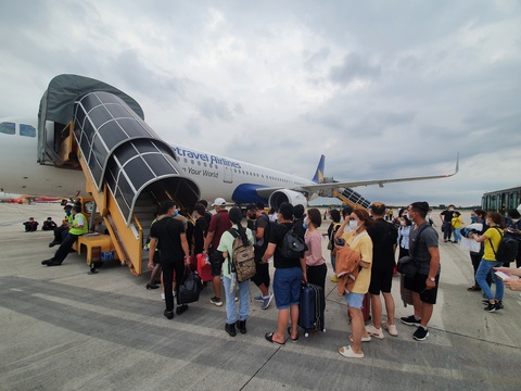 Khách lên máy bay - Ảnh: CÔNG TRUNG Hành khách đi lại bằng máy bay Vietravel Airlines tại Tân Sơn Nhất - Ảnh: C.TRUNG