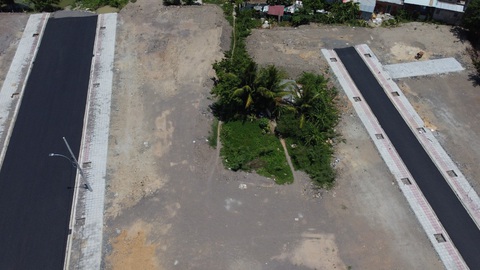 Nha Trang hủy thu hồi đất, nhà dân bị đất đá dự án bao vây - Ảnh 1. Ngôi nhà (cụm màu xanh) của ông Bình nằm lọt thỏm giữa dự án, thấp hơn nền đường khoảng 1m - Ảnh: T.B.