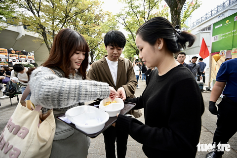Thực khách thưởng thức phở tại công viên Yoyogi, Tokyo, Nhật Bản sáng 8-10 - Ảnh: QUANG ĐỊNH Bạn trẻ thưởng thức các món ngon Việt Nam trong lễ hội