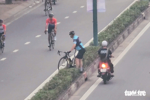 Bất bình với hình ảnh xe đạp vượt đèn đỏ, đi ngược chiều, tạt đầu ôtô - Ảnh 9. Ảnh chụp gần 6h sáng 8-10 trên đường Phạm Văn Đồng, quận Bình Thạnh, cho thấy khi biết lực lượng chức năng đang ở phía trước, một người đi xe đạp khiêng xe qua dải phân cách vào làn trong