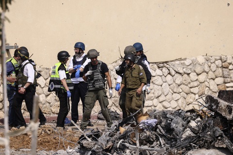 Người Israel cung cấp ADN tìm thân nhân, kể chuyện vợ con bị Hamas bắt cóc - Ảnh 1. Các lực lượng cứu hộ và an ninh tập trung trước một đồn cảnh sát bị hư hại ở thành phố Sderot, Israel vào ngày 8-10 - Ảnh: AFP