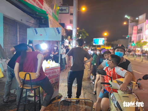 Tiệm bánh đồng xu mọc như nấm khắp TPHCM, đông nghẹt khách - Ảnh 1. Khách xếp hàng tràn xuống lề đường trước một tiệm bánh đồng xu nằm trên đường Phan Văn Trị (quận Gò Vấp) lúc 20h30 tối cuối tuần - Ảnh: NHẬT XUÂN