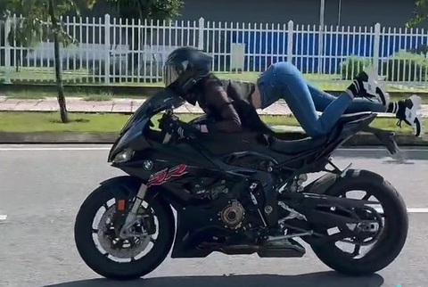 Công an đã gửi giấy mời Ngọc Trinh làm việc vì video 'biểu diễn' mô tô - Ảnh 1. Ngọc Trinh nằm trên xe, sau đó bị té ngã trên đoạn đường trong Khu công nghệ cao - Ảnh: Cắt từ video