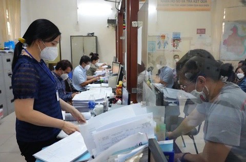 TP.HCM đề xuất có thời gian "đặc thù" sắp xếp nhân sự dôi dư - Ảnh 1. Công chức văn phòng UBND quận Bình Thạnh (TP.HCM) làm thủ tục hồ sơ cho người dân - Ảnh: HỮU HẠNH