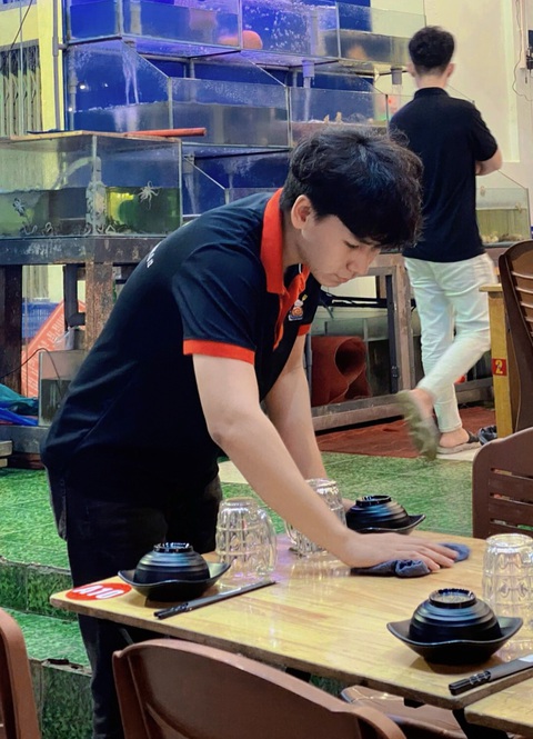 Hùng "xương thủy tinh" với giấc mơ làm MC truyền hình - Ảnh 1. Ngoài giờ đi học, Hùng còn làm tại một quán nhậu để kiếm thêm thu nhập - Ảnh: T.X.