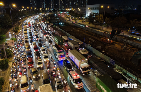 Nút giao An Phú kẹt ‘tứ phía’ đẩy xe máy lên vỉa hè - Ảnh 1. Dòng xe rồng rắn nối đuôi nhau kéo dài khoảng 2km từ hướng hầm Thủ Thiêm về nút giao An Phú (TP Thủ Đức, TP.HCM) tối 10-11