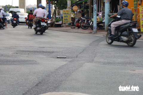 Đường Võ Văn Ngân nham nhở, chủ đầu tư dự kiến 2024 hoàn thành - Ảnh 2. Nhựa mới giặm vá đan xen nhựa cũ tại khúc giao đường Võ Văn Ngân - Đặng Văn Bi như "tấm áo vá". Trả lời Tuổi Trẻ Online về giải pháp khắc phục tình trạng đường Võ Văn Ngân, ông Nguyễn Tuấn Khanh - giám đốc Ban quản lý dự án đầu tư xây dựng khu vực TP Thủ Đức - cho biết dự án xây dựng hệ thống thoát nước đường này đang tạm ngưng, các hạng mục ngầm chưa thi công hoàn chỉnh. Điều này dẫn tới chưa đảm bảo việc tái lập được, người dân gặp khó khăn khi qua đây - Ảnh: NGỌC QUÝ