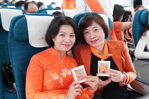 Vietnam Airlines thực hiện chuyến bay truyền thông điệp về bình đẳng giới - Ảnh 1. Hành khách nhận quà mang thông điệp bình đẳng giới trên chuyến bay của Vietnam Airlines - Ảnh: M. NGỌC