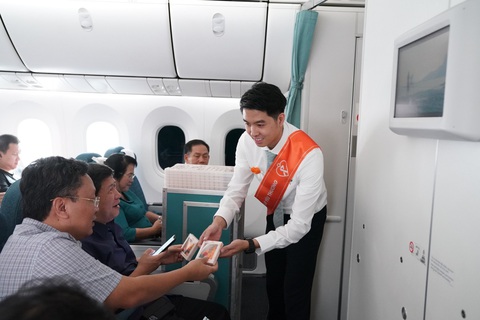 Vietnam Airlines thực hiện chuyến bay truyền thông điệp về bình đẳng giới - Ảnh 3. Hành khách nam trên chuyến bay nhận những món quà màu cam biểu tượng cho chiến dịch toàn cầu về xóa bỏ bạo lực đối với phụ nữ và trẻ em gái - Ảnh: M.NGỌC
