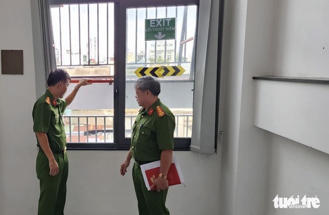 TP.HCM: Sẽ kiểm tra phòng cháy, chữa cháy trong cơ quan nhà nước - Ảnh 1. Đoàn kiểm tra khu vực cửa thoát hiểm tại tòa nhà - Ảnh: MINH HÒA