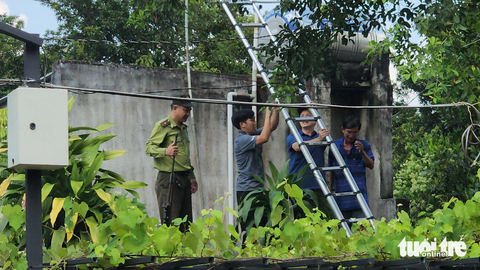 Khỉ đuôi lợn tấn công ít nhất 2 người bị thương ở quận 12 - Ảnh 3. Sáng 11-11, kiểm lâm phối hợp với lực lượng chức năng và người dân địa phương tìm kiếm, bắn thuốc gây mê con khỉ xuất hiện tại một số nhà dân ở Tân Thới 1 (xã Tân Hiệp, huyện Hóc Môn) - Ảnh: NGỌC KHẢI