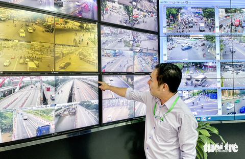 Phạt nguội xe quá tải: Xem mọi thứ qua camera, dữ liệu truyền về từ xa - Ảnh 1. Ông Bùi Quang Dũng - phó đội trưởng đội vận hành giám sát giao thông, chỉ tay về hướng camera quan sát khu vực 2 trạm cân thí điểm phạt nguội tải trọng xe - Ảnh: CHÂU TUẤN