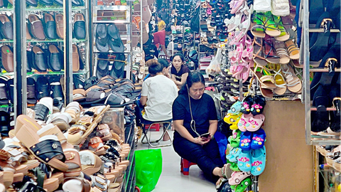 Chợ vắng hoe, tiểu thương ngồi buồn, lo mất Tết - Ảnh 2. Người bán nhiều hơn khách mua, hàng loạt tiểu thương tại chợ An Đông ngồi chơi điện thoại “giết thời gian” - Ảnh: NHẬT XUÂN