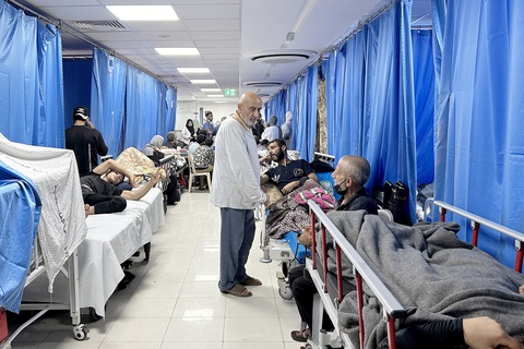 Hệ thống y tế "ngã gục" ở Gaza - Ảnh 1. Bệnh nhân và người tị nạn trú ẩn bên trong Bệnh viện Al Shifa ở thành phố Gaza ngày 10-11 trong khi tử thi la liệt bên ngoài - Ảnh: AFP