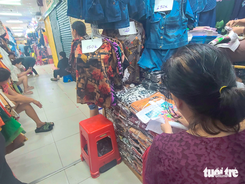 Chợ vắng khách, tiểu thương nghĩ ra đủ kiểu 'giết thời gian' - Ảnh 6. Một số tiểu thương lớn tuổi chọn thêu thùa, móc len "giết thời gian" lành mạnh - Ảnh: NHẬT XUÂN
