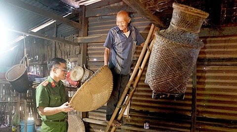 Anh công an trẻ đam mê văn hóa Tây Nguyên - Ảnh 3. Già Y Pyong, bon Ka Nur, xã Quảng Khê (Đắk Glong, Đắk Nông), người dân tộc M'nông, năm nay đã ngoài 100 tuổi, cẩn thận hướng dẫn những nét văn hóa truyền thống cho anh Bộ
